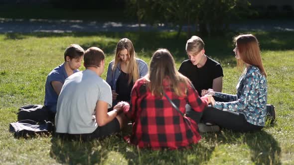 Young Christians Sitting in Circle and Praying alt