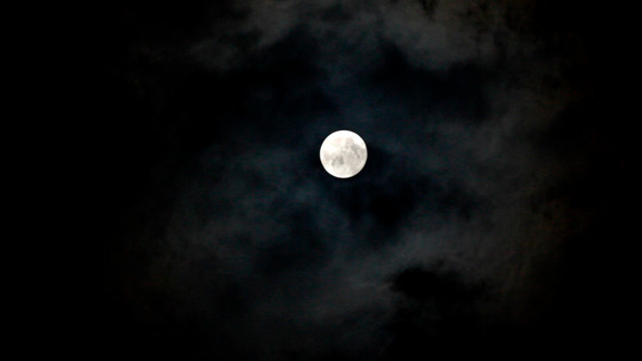 Moon Moving Between Clouds