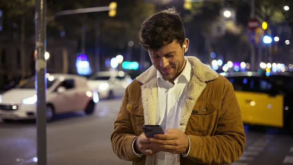 Man Using Smartphone on Night Street