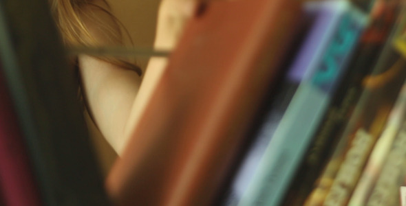Girl Takes a Book From The Shelf alt