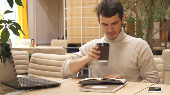 Man Drinks Coffee at the Working Hub