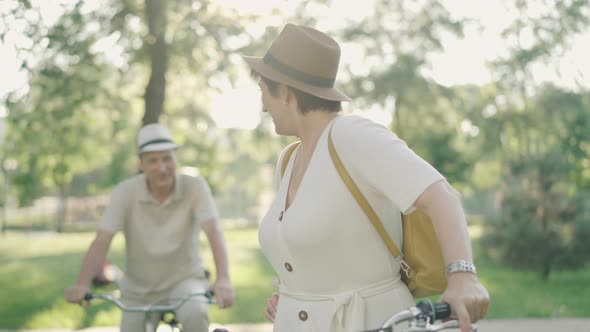 Elegant Mid-adult Caucasian Woman Talking To Smiling Blurred Man at the Background, Turning To