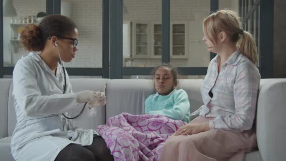 Female Doctor Examining Child with Stethoscope