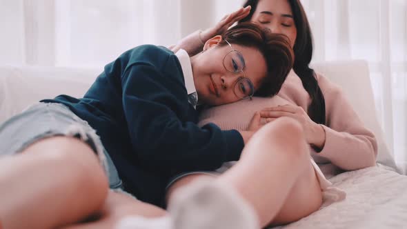 Pregnant Asian lesbian woman and her partner are happy to spend time together at home.