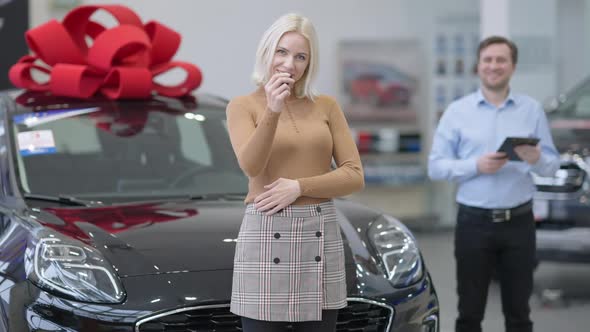 Charming Blond Young Woman Turning To Camera Showing Car Keys and Crossing Hands