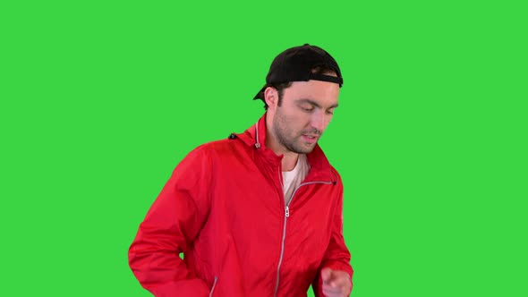 Young Man Running in a Windbreaker on a Green Screen Chroma Key