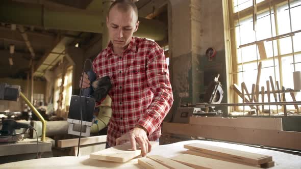 Caucasian Middleaged Balding Male in Plaid Red Shirt Using Router in Joinery