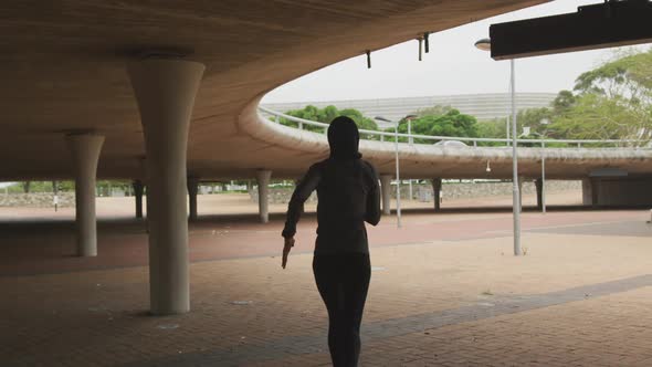 Rear view of woman wearing hijab running outside