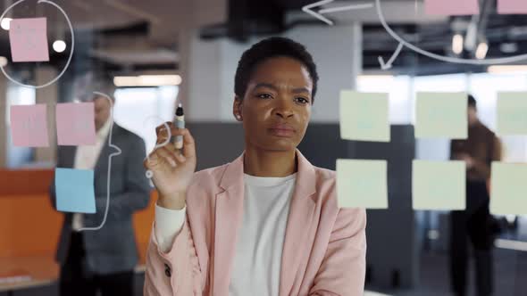 Serious Woman Manager Examining Information on Sticky Notes and Finding Solution