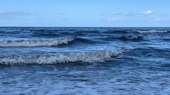 Blue waves roll into the coast.