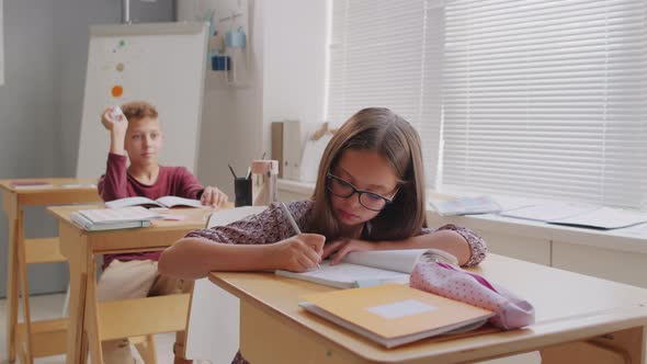 Boy Throwing Paper at Girl in Class