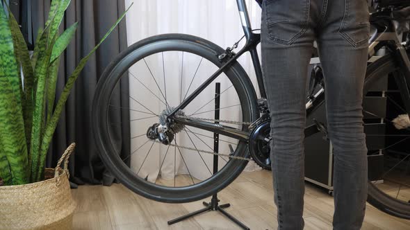 Mechanic takes bike off from rack in bicycle workshop. Repair bicycle in cycling workshop