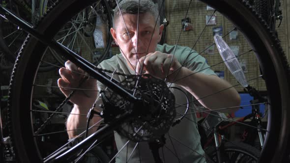 Service Engineer Performs Diagnostics and Repairs of Bicycle in Professional Workshop