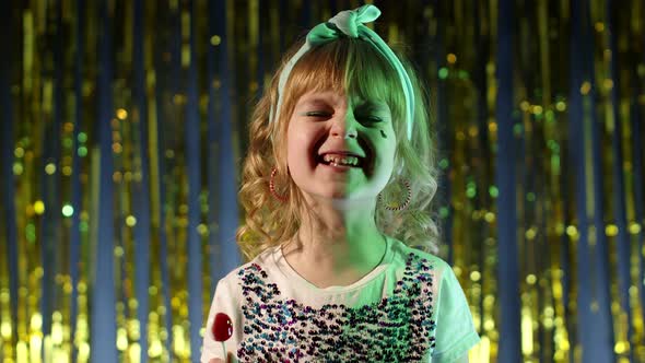 Child Kid in Neon Lighting Posing at Disco Party Cyberpunk Studio Girl Making Faces Fooling Around