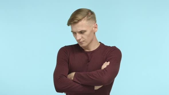 Handsome Blond Man Looking Troubled and Complicated Cross Arms on Chest Looking at Camera Serious