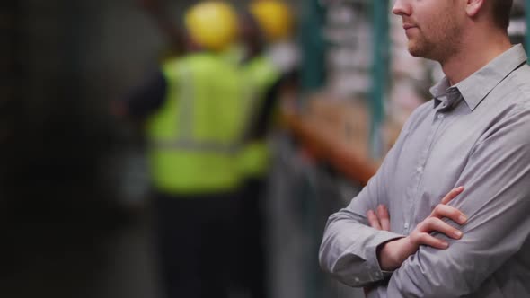 Caucasian male factory worker at a factory looking and smiling to the camera