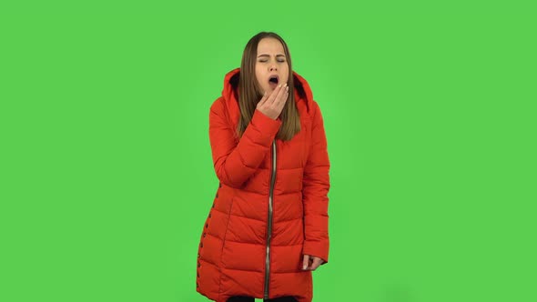 Lovely Girl in a Red Down Jacket Is Getting a Cold, Sore Throat and Head, Cough. Green Screen