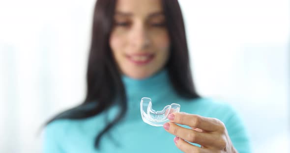 Woman Holding Night Plastic Dental Cap in Her Hands Closeup  Movie Slow Motion