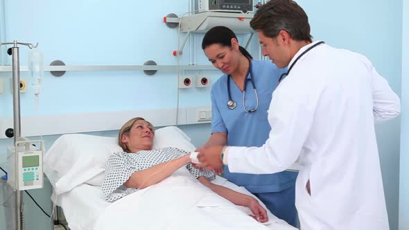 Doctor and nurse looking at a blonde patient