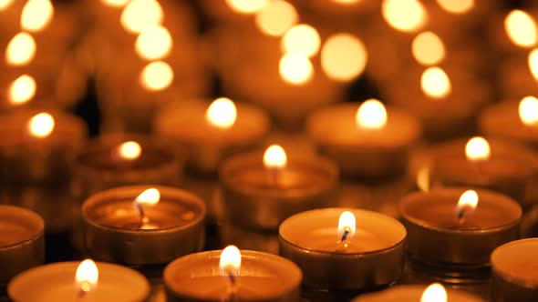 Many Small Burning Candles on a Black Background alt