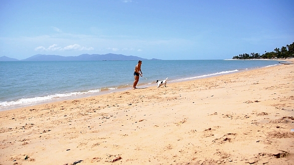 Man and Cute Dog Playing on Seacoast