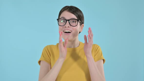 Cheerful Young Woman Clapping on Purple Background 