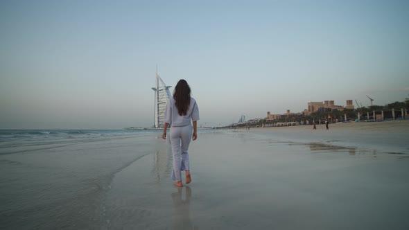 Female Tourist Walking on the Beach in Dubai in Front of Burj Al Arab