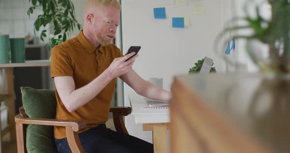 Albino african american man with dreadlocks making video call on the laptop