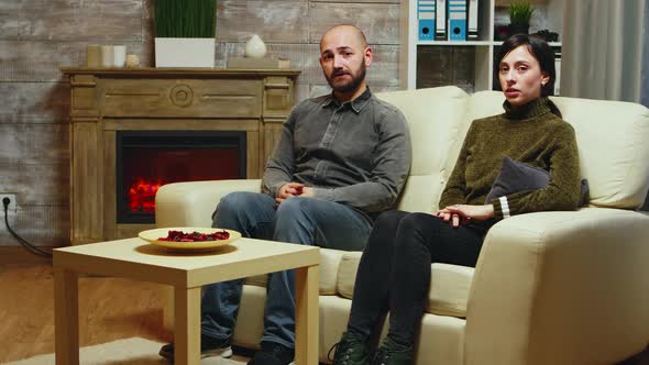 Nervous Young Couple Sitting on Couch