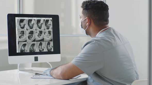 Doctor Examining CT Scan on Computer in Medical Office