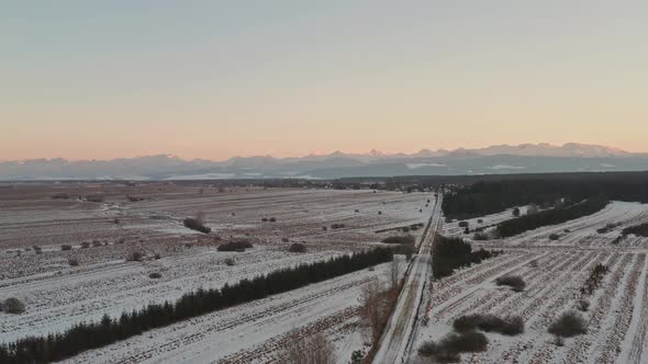Sunset at winter rural landscape in Slovakia with distant mountains, aerial