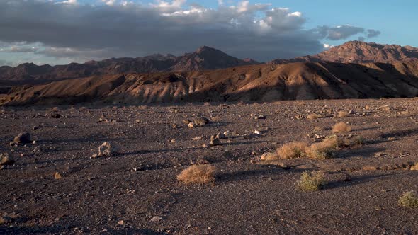 Arid ground with dry shrubs in Mojave Desert, California with Sierra Nevada in the distance, Aerial
