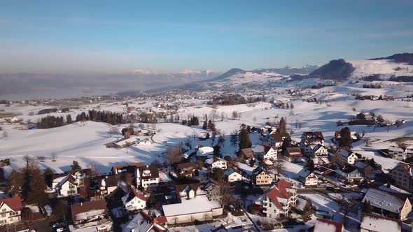 Flight over a small village in Switzerland while winter.