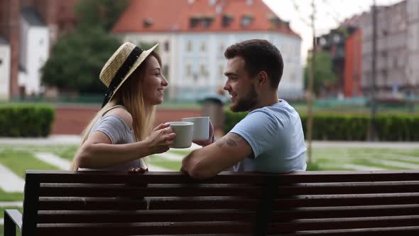 Young couple drinking tea while sitting on a bench in Wroclaw, Poland