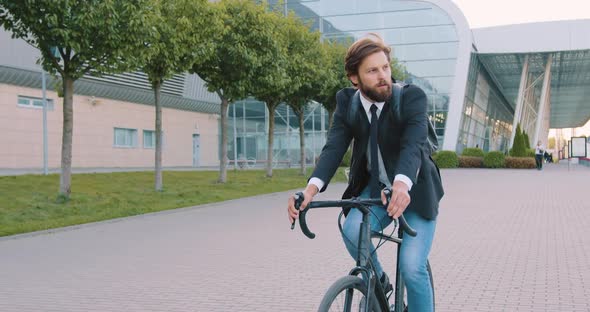 Businessman with Backpack in Formal Clothes Riding a Bicycle to His Office