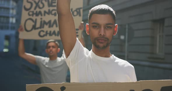 Two mixed race men on a protest march holding placards raising hands and shouting