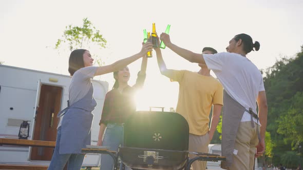 Group of Asian man and woman friend having holiday party outdoor in the evening together in camp.