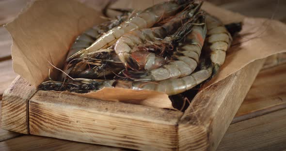 A Wooden Tray with Raw Shrimp Slowly Rotates on Table. 