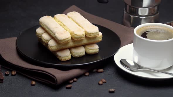 Italian Savoiardi Ladyfingers Biscuits and Cup of Coffee on Concrete Background