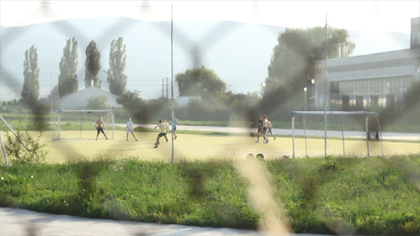 Kids Playing Football after Fence