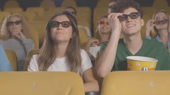 Portrait of Happy Young Couple Discussing Film in Cinema. Cheerful Caucasian Young Man and Woman in