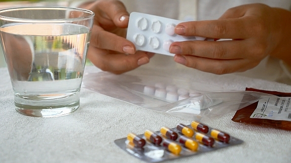 Female Hands with Packings of Pills