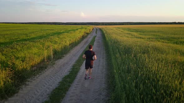 Caucasian Man Running on the Country Road at Sunset