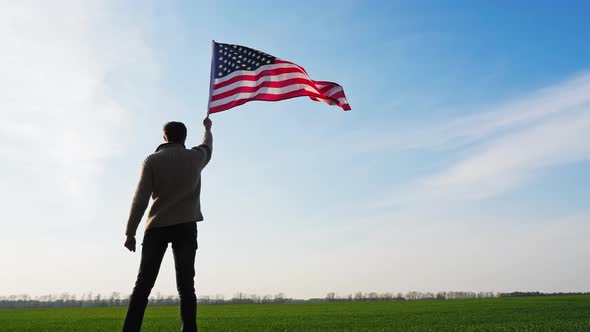 Man Holding a Large Flag of the United States of America