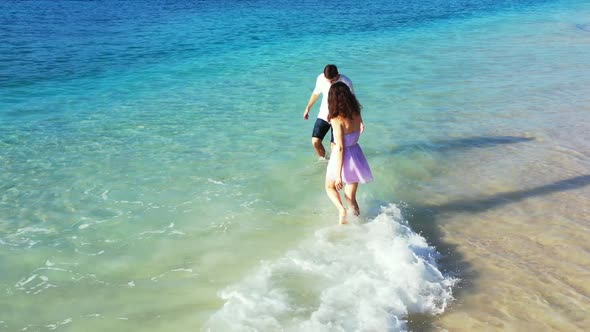 Teenage lovers in love on idyllic island beach time by blue lagoon and white sand background of Gili