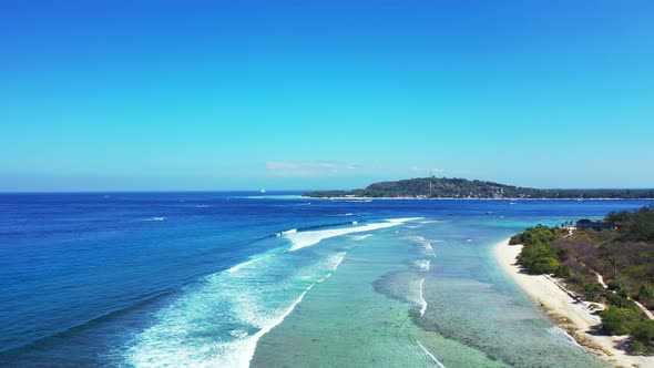 Daytime flying travel shot of a white paradise beach and aqua turquoise water background in vibrant 