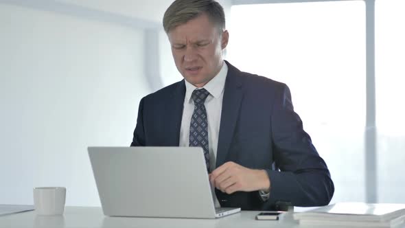 Businessman with Back Pain Working on Laptop