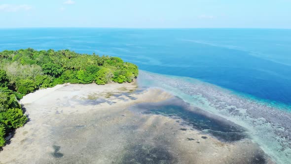 Aerial: flying over tropical Ai island coral reef sand beach Banda Islands