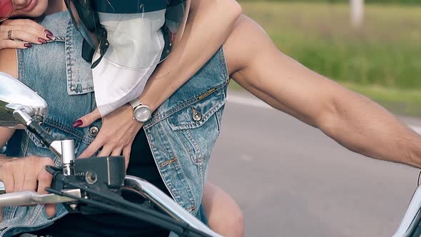 Close View Girl Hand Hugs Muscular Man on Motorcycle