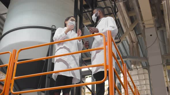 Low Angle View of Engineers Wearing Lab Coat Standing Near Machines Working at Dairy Factory